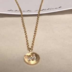 A necklace with an engraved letter M